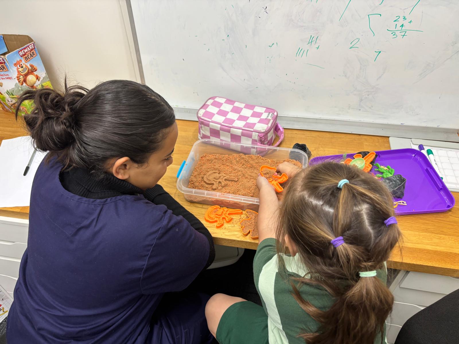 NCP therapist guiding a child through sensory sand play inside the Minchinbury clinic